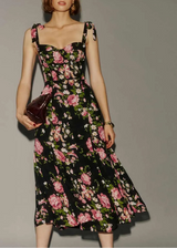 Woman wearing a black floral dress against a gray background