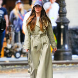 Woman in a trench coat walking on a street with blurred background