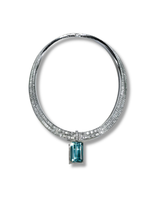 Jewelry with a blue gemstone and diamond-studded band on a white background