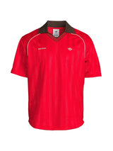 A red short-sleeve Adidas V-neck jersey with a dark brown collar, white piping details, and white embroidered logos on the chest.