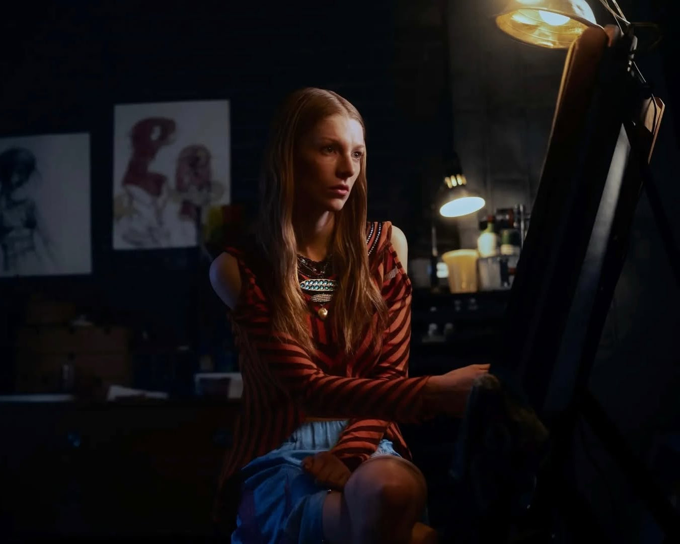 Two people standing close together with a warm light source in the background