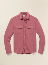 Pink button-up shirt with two chest pockets on a beige background