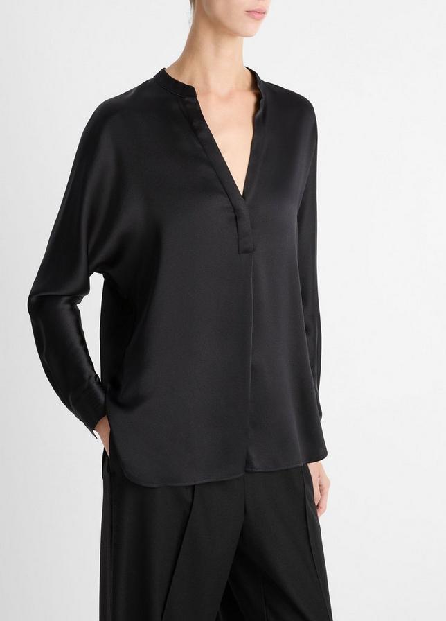 Person wearing a black blouse with a V-neck and long sleeves on a white background