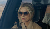 Woman wearing sunglasses sitting in a car with a blurred background