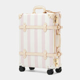 Striped suitcase with gold accents on a white background