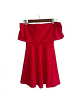A red off-the-shoulder mini dress shown both worn by a woman in a dimly lit scene and as a standalone product on a hanger against a white background.