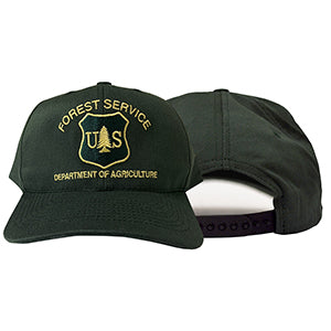A dark forest green baseball cap with gold embroidered text reading 'FOREST SERVICE' and 'DEPARTMENT OF AGRICULTURE' around a 'U.S.
