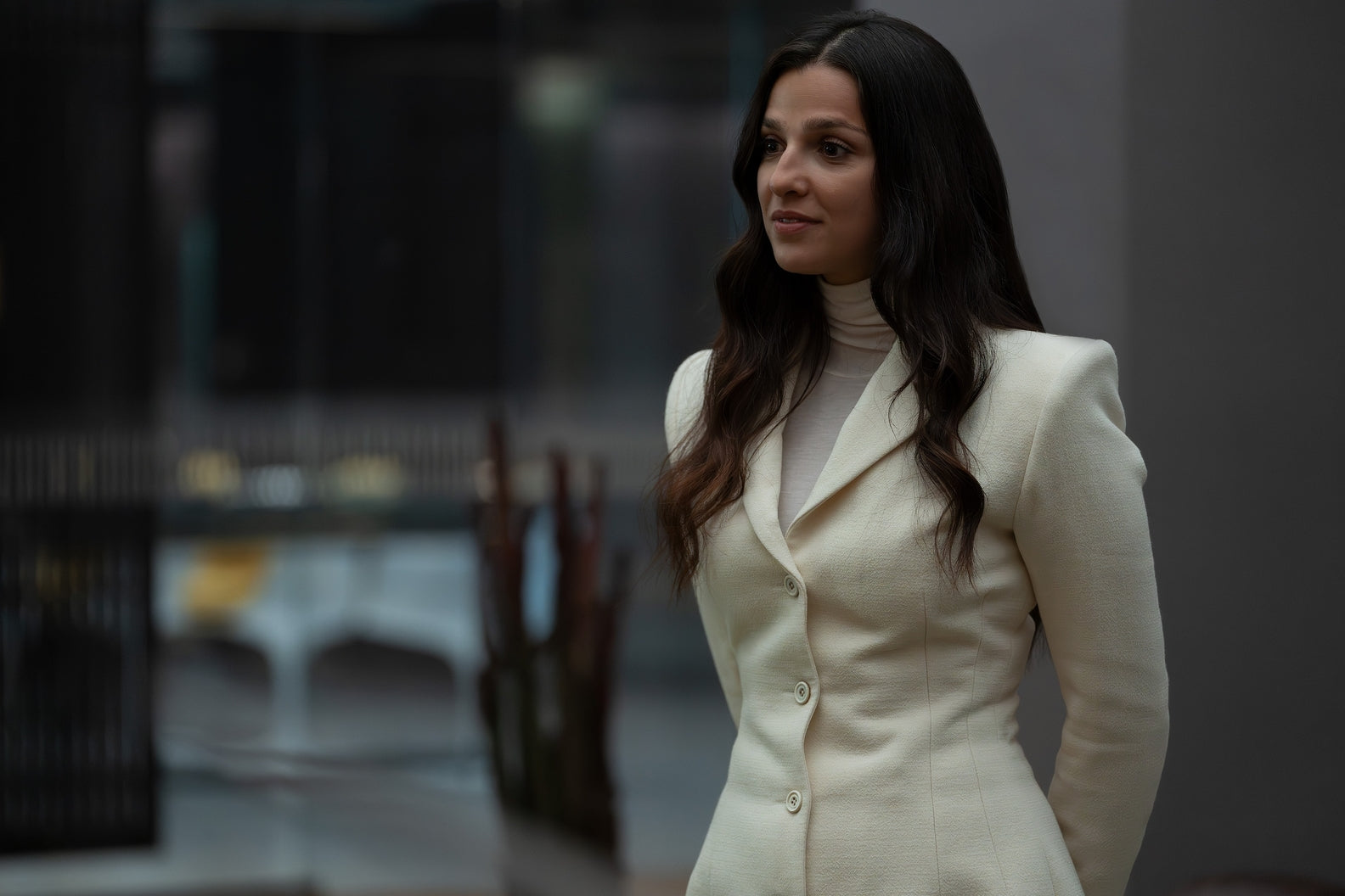 Woman in a white suit standing in an urban setting
